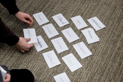 Index cards laid out in a pyramid with leadership qualities listed on each of them.