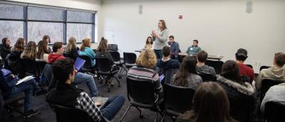 Person presenting in front of large group of people