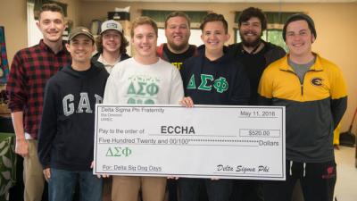 Members of the fraternity Delta Sigma Phi with a large check for the Eau Claire County Humane Association