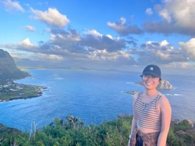 Chinese student on the Hawaiian coast on a high mountain ridge 