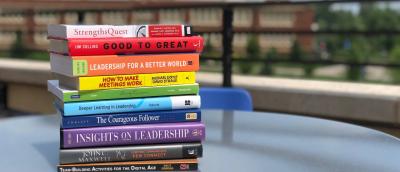 Leadership books stacked on a table