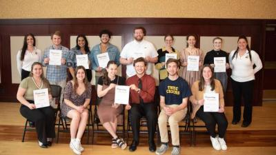 Winners of the University Student Excellence Awards sitting and standing as a group