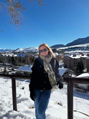 A young woman stands in a snowy field.