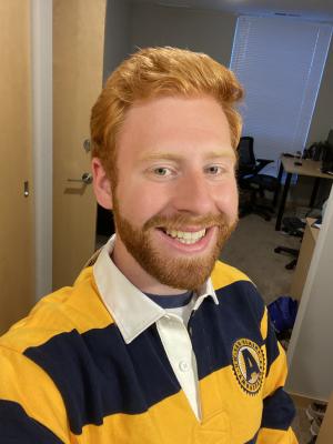 A headshot of smiling Jack Petrizzo in the UWEC student Ambassador blue and gold striped shirt.