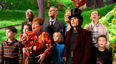 A group of children and adults in the Willy Wonka factory looking concerned.