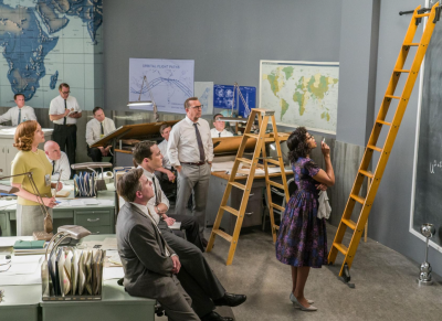 room of scientists watching a Black woman solve a mathematical puzzle. 