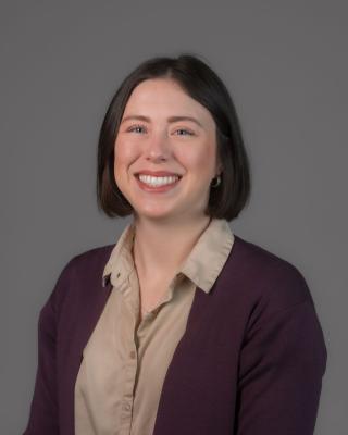Joann headshot wearing purple cardigan and button up shirt