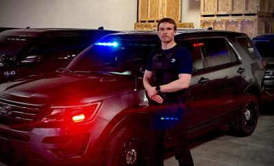 Ian Johnson next to squad car 