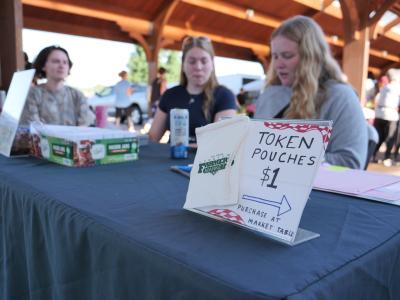 students at token table at Farmer's Market 