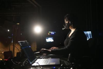 student at sound board backstage in theater