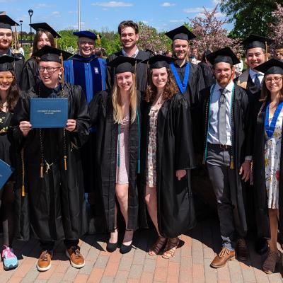 group of geology graduates with Dr. Scott Clark, all in gowns 