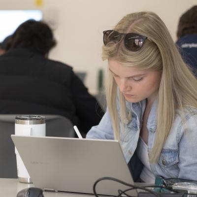student at a laptop in a classroom 