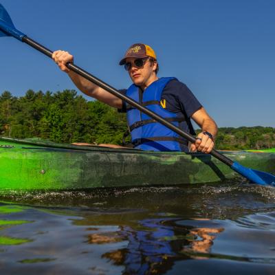 A student kayaks across the Chippewa River