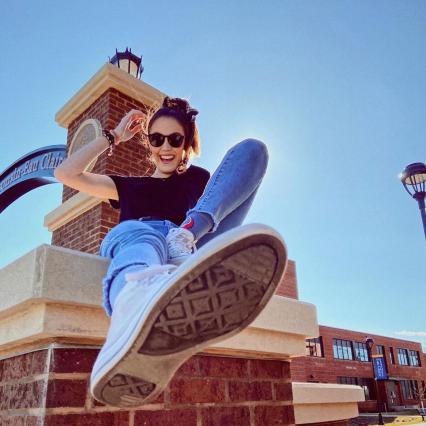 A girl sitting on a chimney on a sunny day