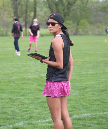 Nora Mitchell holding a clipboard on a sport field.