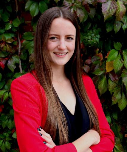 Headshot of Casey Schumacher from the shoulders up smiling in a professional blazer.