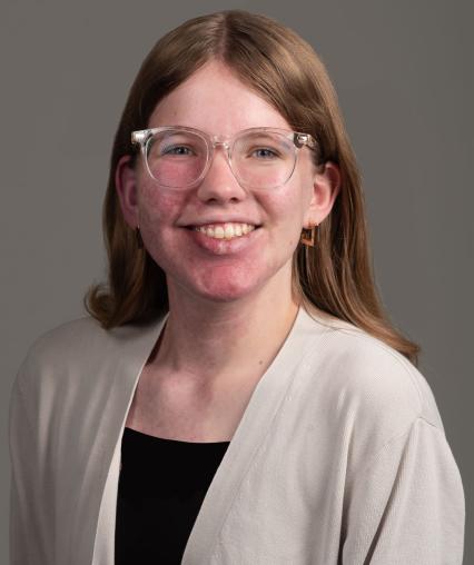 Woman with clear glasses and long dark blonde hair.