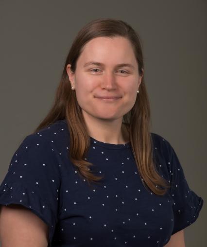 An image of a smiling woman with mid-length brown hair