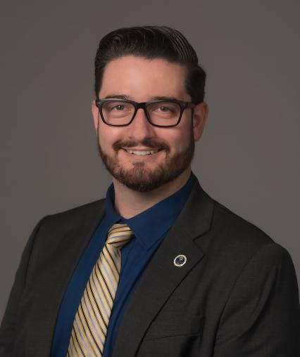 Jake Wrasse pictured wearing a suit and a blue and gold tie