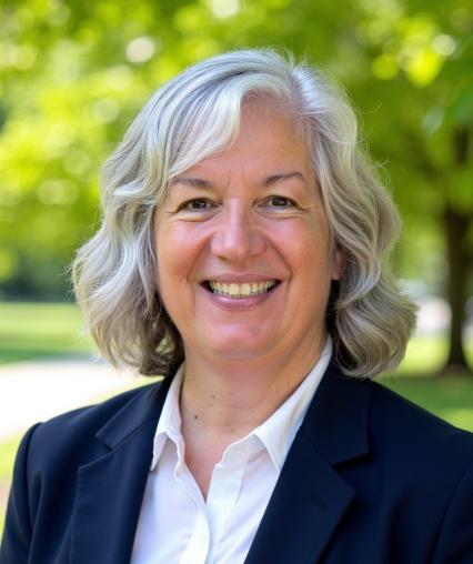 Headshot of Dean Kristen Abbott-Anderson wearing white blouse and navy blue jacket in an outdoor setting
