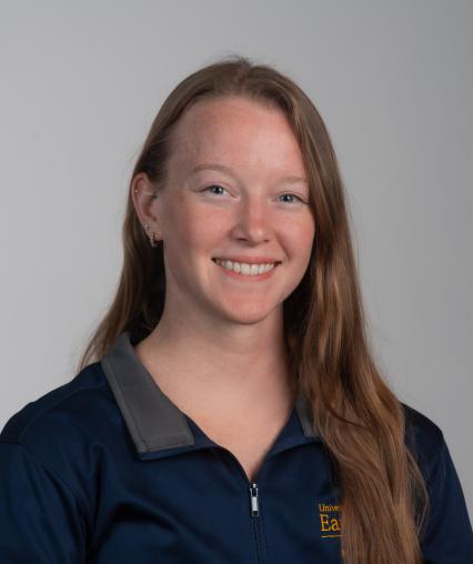 Image shows a woman in a Housing and Residence Life quarter zip. 