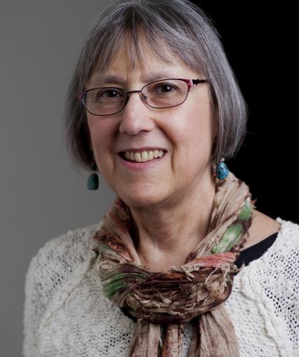 A woman with glasses smiling