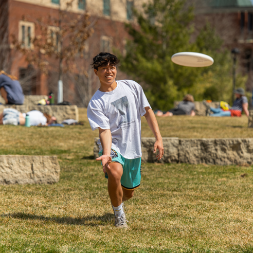 A picture of student playing frisbee at the UWEC campus mall