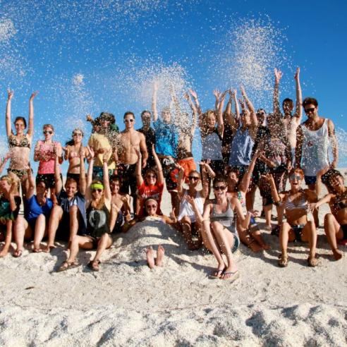 A group photo of students on a study aboard trip to Australia, Perth on a bright, sunny beach