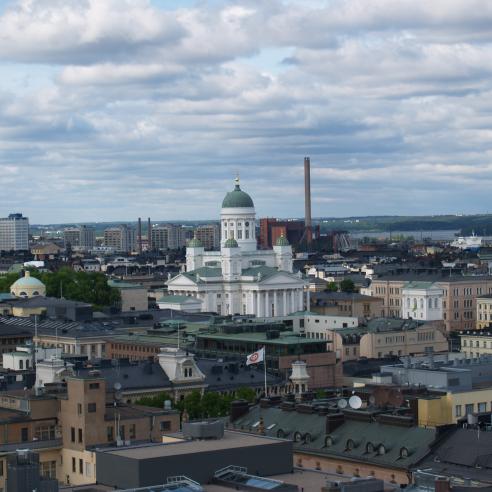 A view of Helsinki, featuring the iconic Helsinki Cathedral amidst a backdrop of urban architecture and industrial structures.