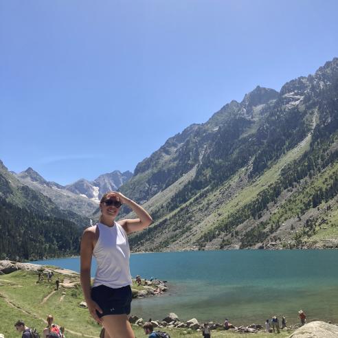 A picture of student during study aboard in France standing at the edge of a mountain lake