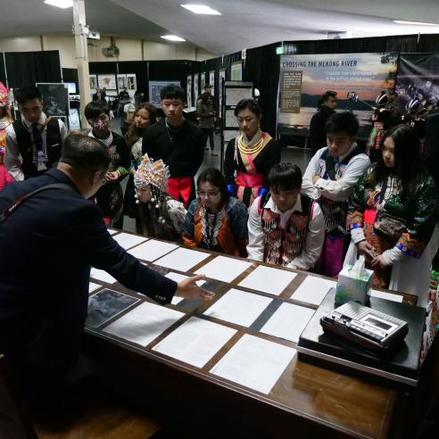 An image of group of student wearing Hmong culture attire listening to the speaker