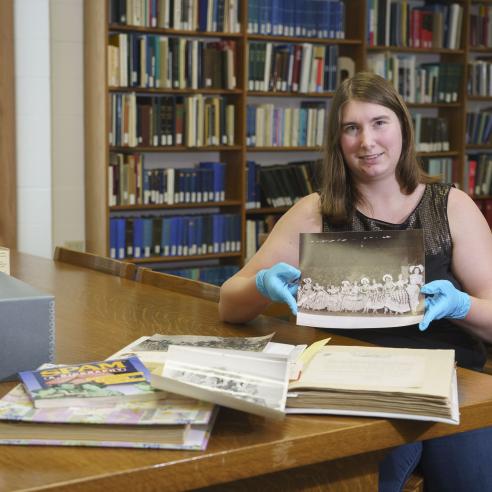 An individual holding pictures in library