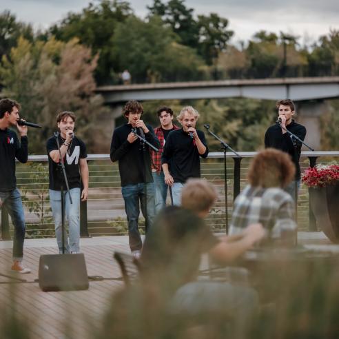 A picture of the Innocent men member sing cappella on campus