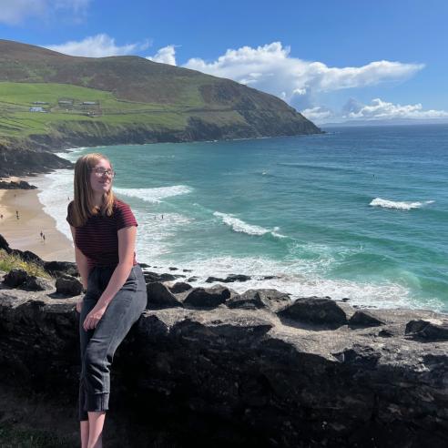 a picture of student during study aboard in Ireland on a coastal cliff with a stunning view of a sandy beach