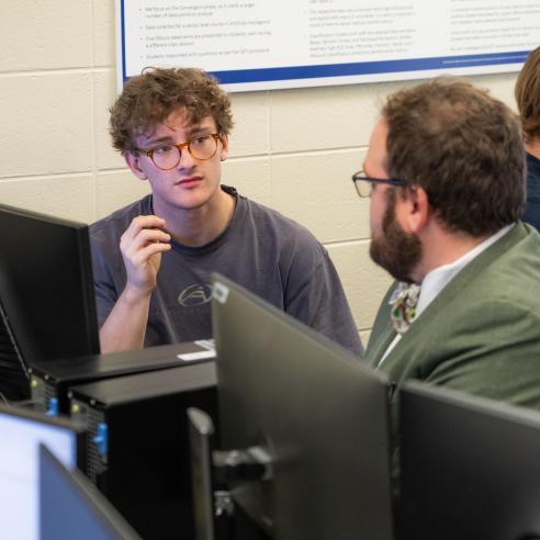 Student and professor discussing in the computer room