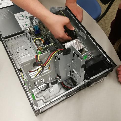 A picture of individual working on the internal components of a desktop computer