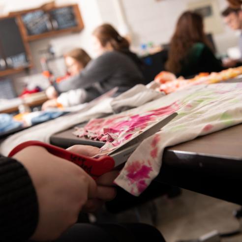 students cutting colorful fabric in makerspace