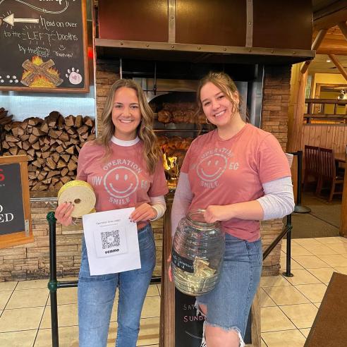 A picture of two students from operation smile doing fundraising 