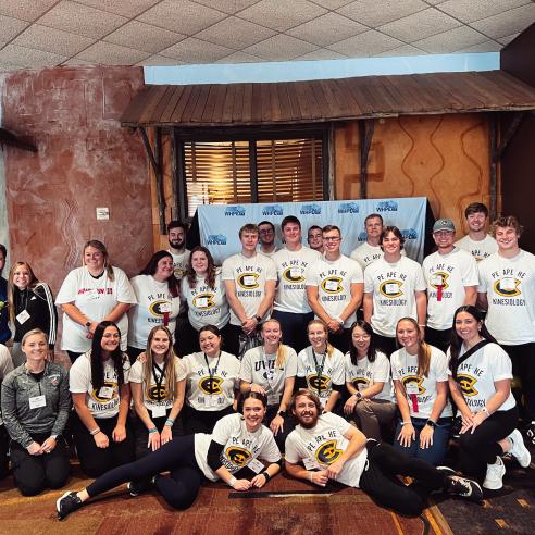 A picture of a group of people wearing "PE APE HE Kinesiology" at WHPE convention