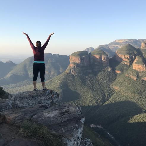 a picture of student during study aboard in South Africa on top of the rocky outcrop, with a breathtaking view of the Blyde River Canyon in South Africa