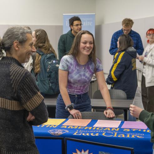 A lively scene of students from the club engage with visitors