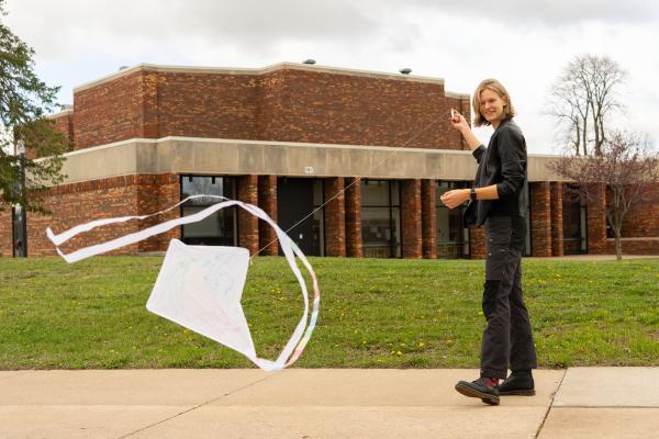 student flying white kite on Barron County campus