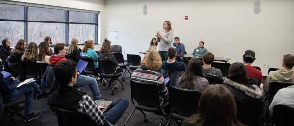 Person presenting in front of large group of people