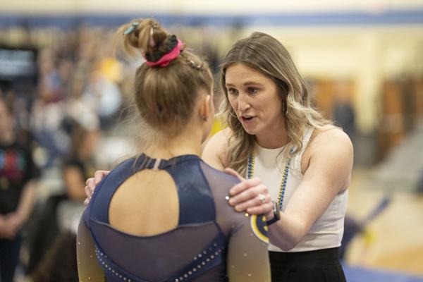 Jessie DeZiel with a Blugold gymnast at a meet
