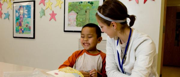 Student volunteer with a child smiling