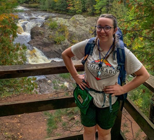 Lyndsie Vickers near a small waterfall in front of a railing edge
