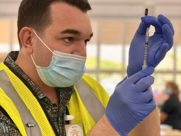 Jacob Schafer administering COVID-19 vaccine 