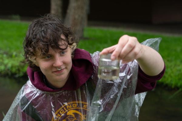 Student collecting insects from Niagara Creek for freshwater research 
