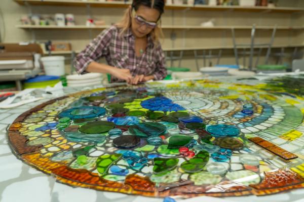 art faculty working on stained glass panel 