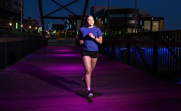 A student runs downtown Eau Claire during a summer evening.